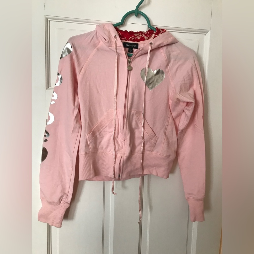 Bebe light pink sport hoodie w/silver print. Sz M. New no tags.